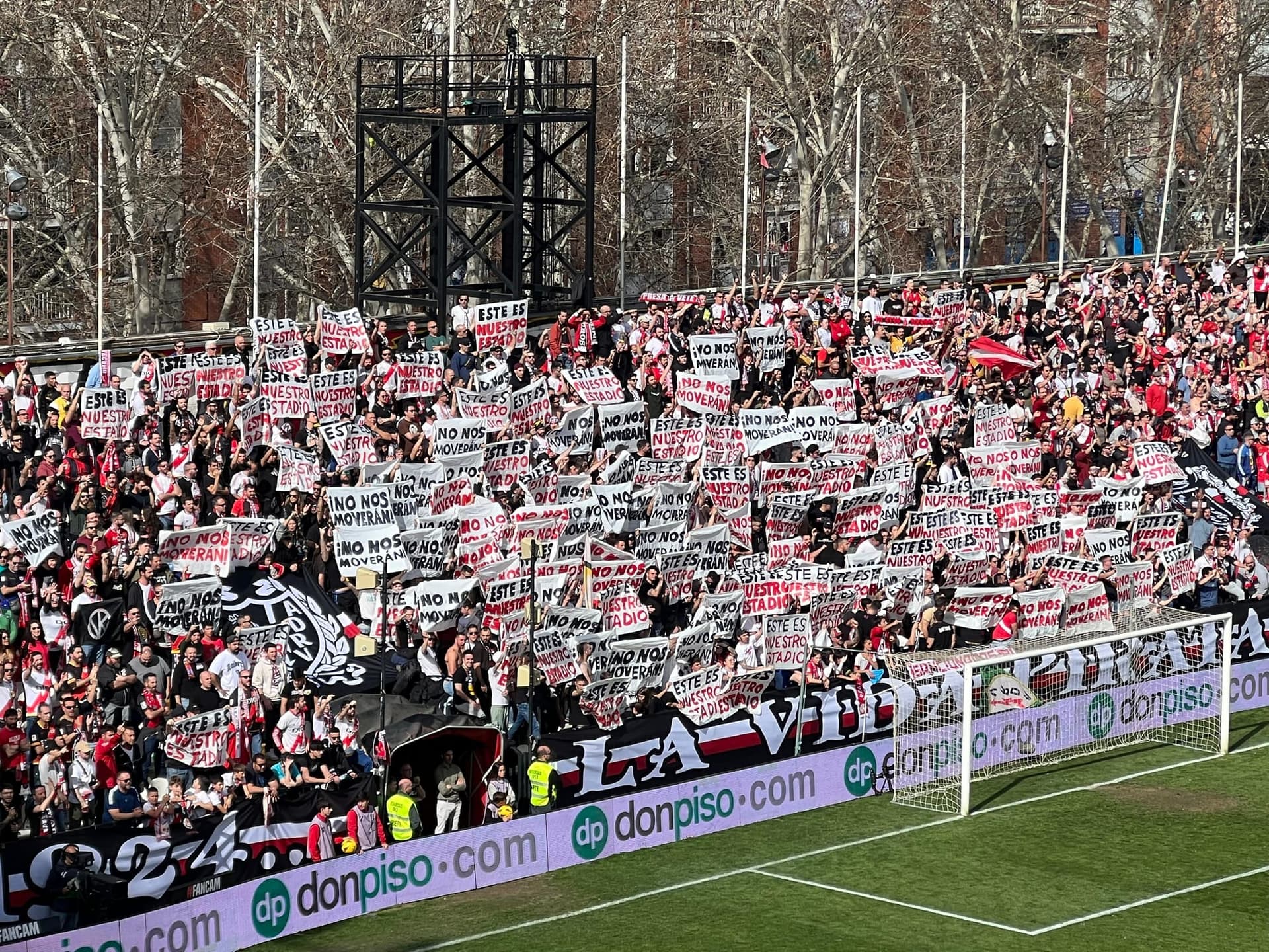 Rayo Vallecano supporters in the Fondo holding “Este es nuestro estadio” and “No nos moverán” placards