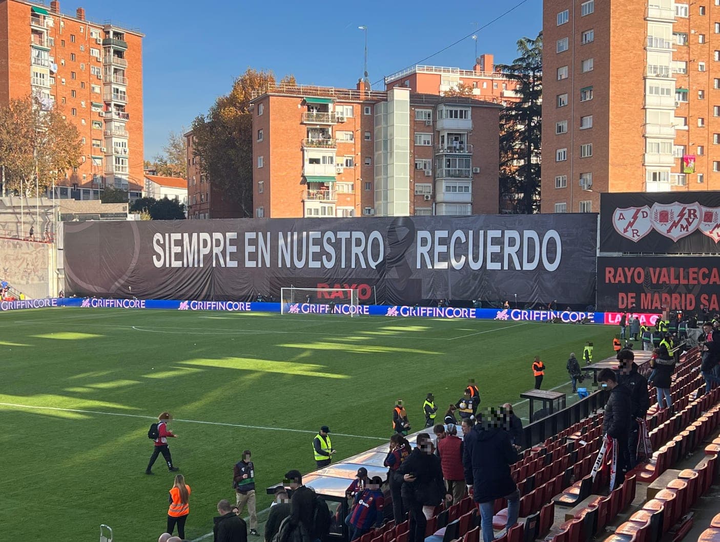The missing east stand at Vallecas, with the “Siempre en Nuestro Recuerdo” banner and the balconies overlooking the pitch